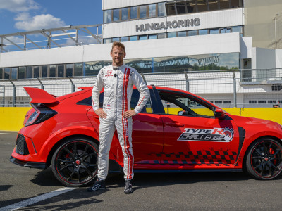 A victorious Jenson Button stands next to his winning Type R