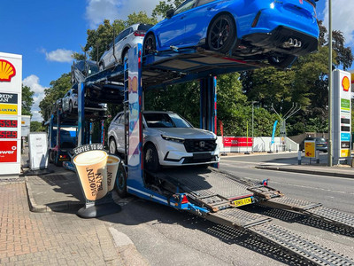 A 2024 Honda CR-V in Diamond Dust Pearl drives off the transporter
