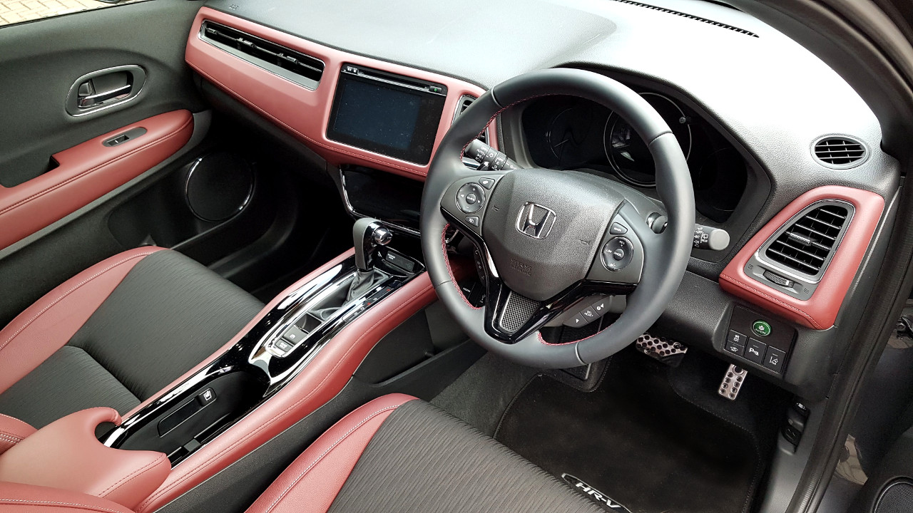 The Honda HR-V Sport features a sporty two-tone red and black interior