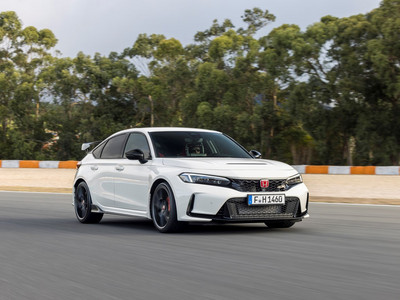 A white 2023 Honda Civic Type R driving around a racing circuit