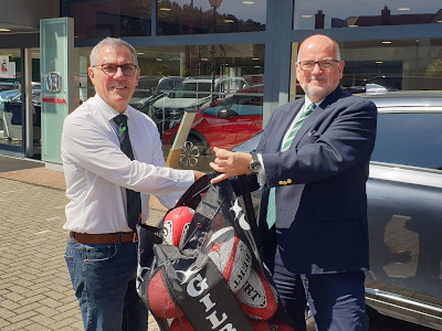 Trident Honda Managing Director, Richard Roberts, hands over record-breaking rugby balls to Ken Sewell, Chairman of the Weybridge Vandals